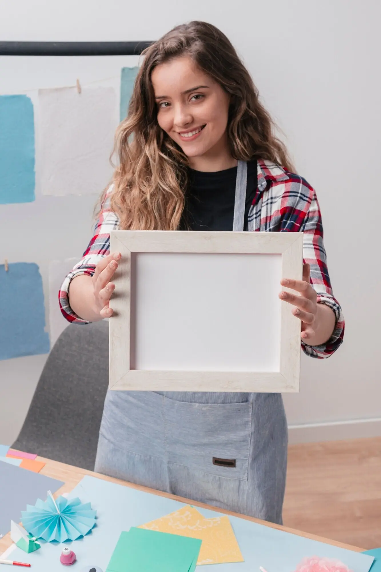 Moderne Frau zeigt einen weißen leeren Rahmen